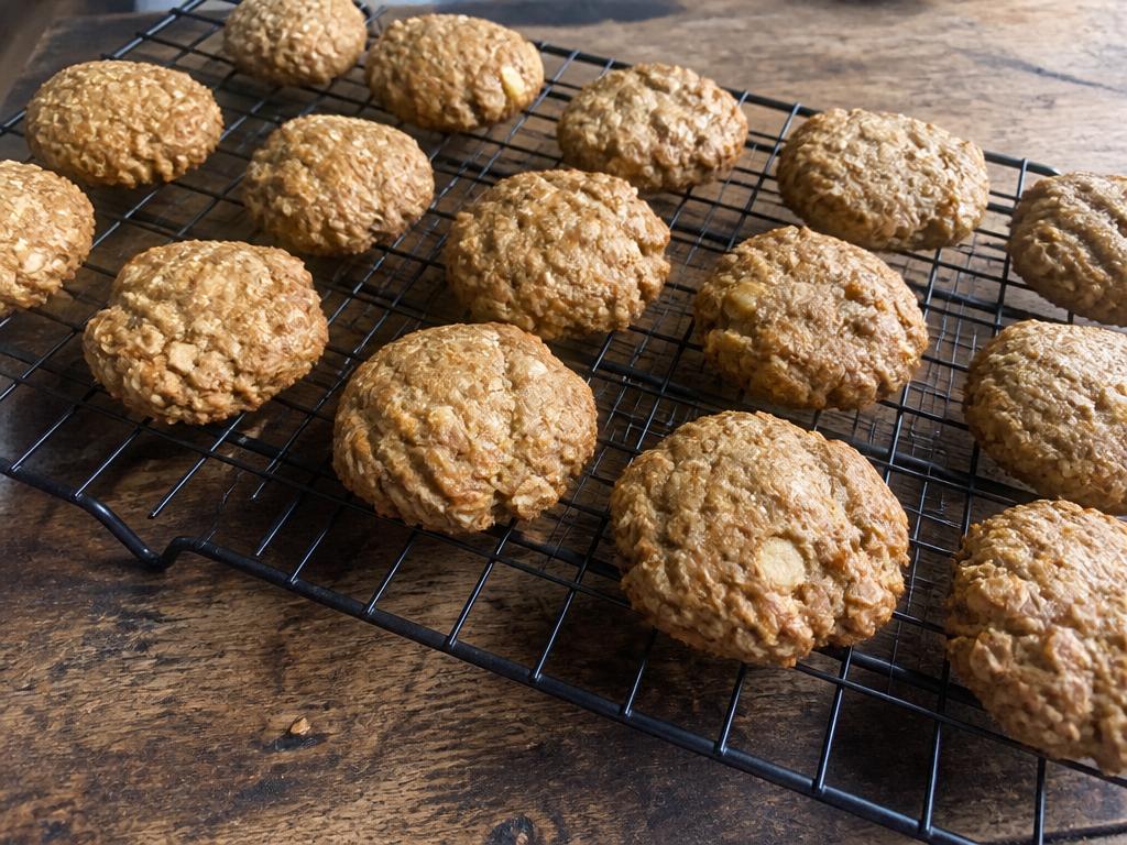 Small rustic apple peanut butter oat dog cookies cooling on a wire rack