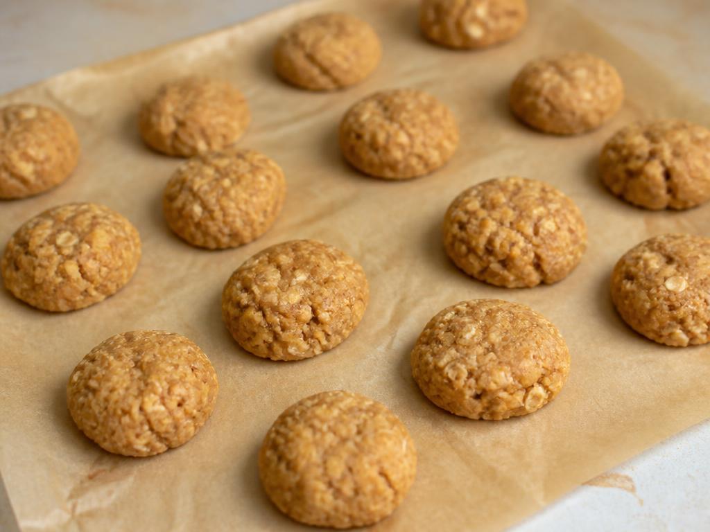 Small homemade peanut butter and banana oat dog treat bites on baking parchment