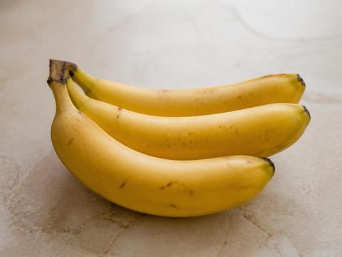 Ripe yellow bananas arranged on a light kitchen surface