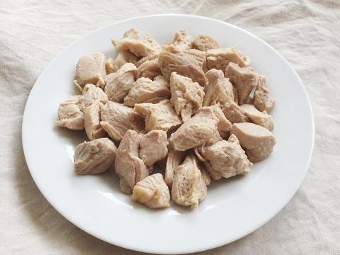 Bite-sized pieces of plain cooked boneless, skinless chicken meat on a white plate