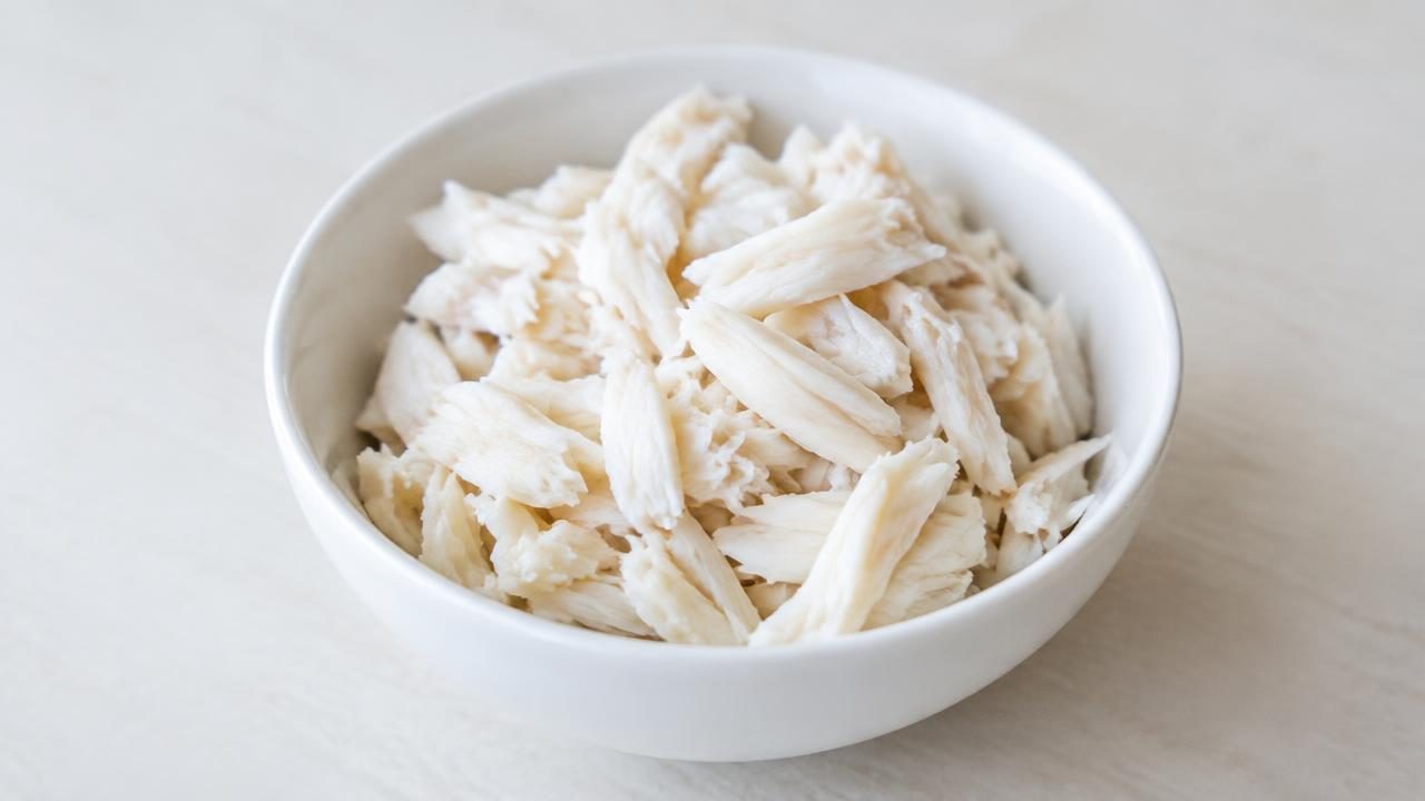 Plain cooked white crab meat in a small bowl, with no shell.