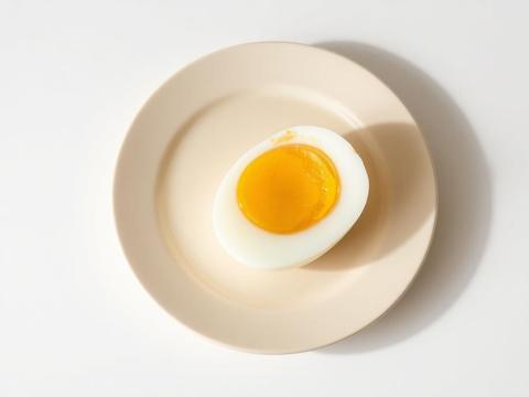A halved boiled egg on a cream ceramic plate